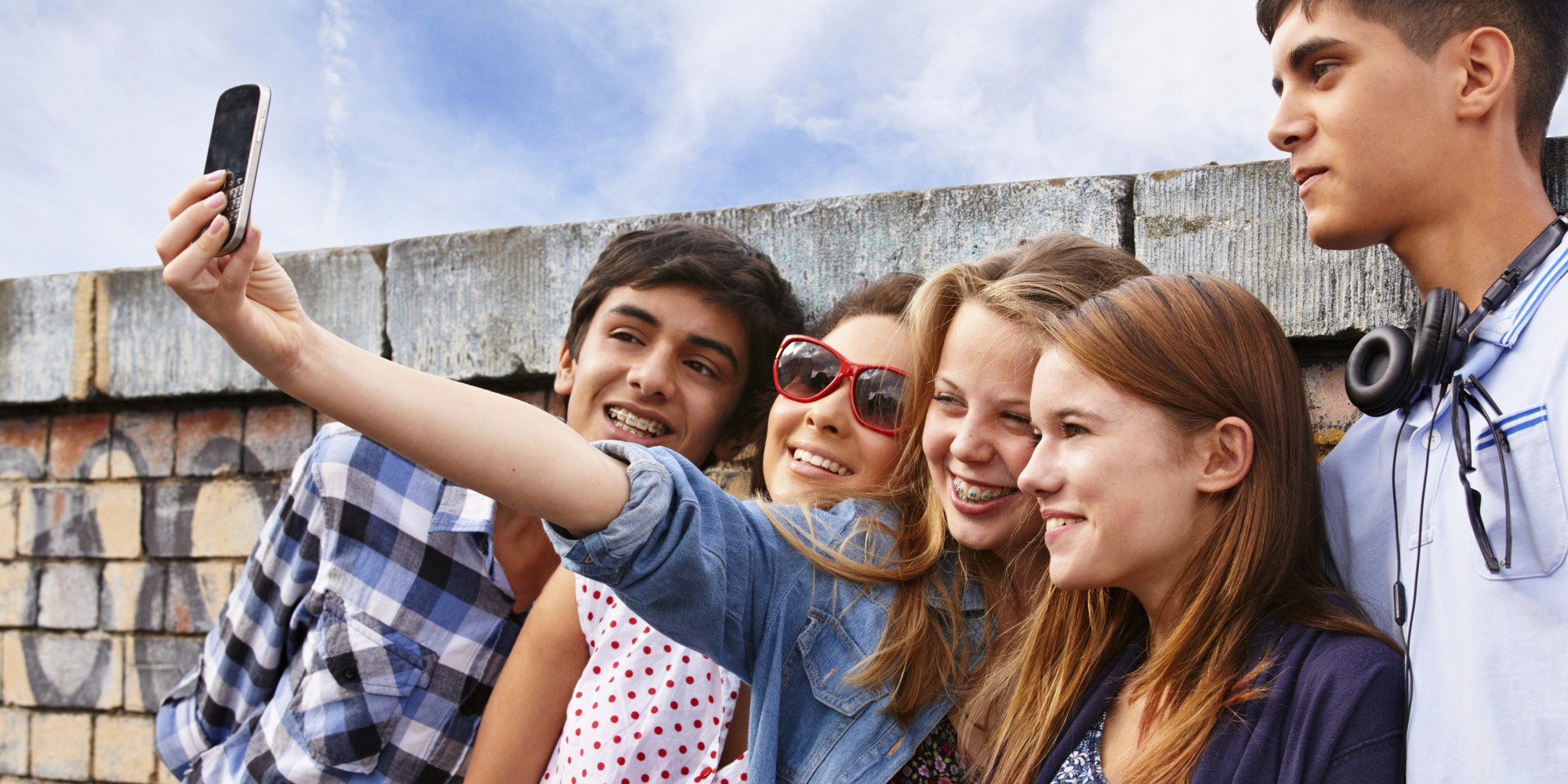 Amigos adolescentes fotografiándose con smartphone