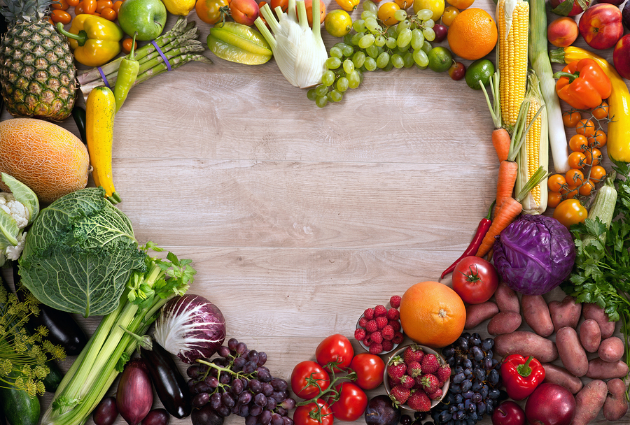 fotografía de comida de corazón hecha de diferentes frutas y verduras en mesa de madera